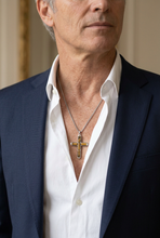 Charger l'image dans la galerie, Pendentif croix œil de tigre raccourci, porté avec une chemise blanche plus ouverte et une veste de costume
